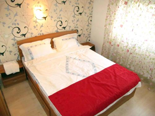 シビウにあるApartament Liraの小さなベッドルーム(赤い毛布付きのベッド付)