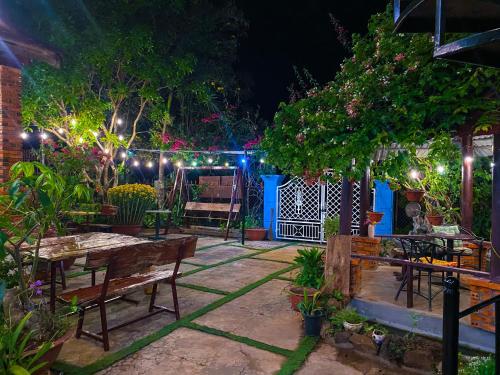 un patio con mesas y bancos por la noche en Dorry Le's House, en Gia Nghĩa