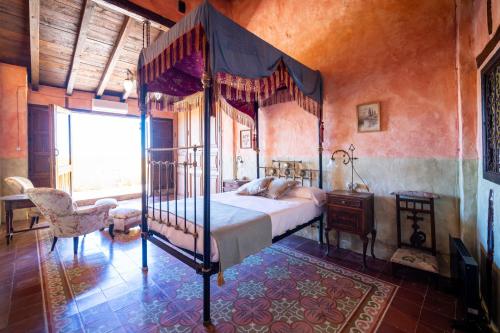 a bedroom with a four poster bed and a window at Casa Museo RAKKANA - En el Centro de Requena in Requena