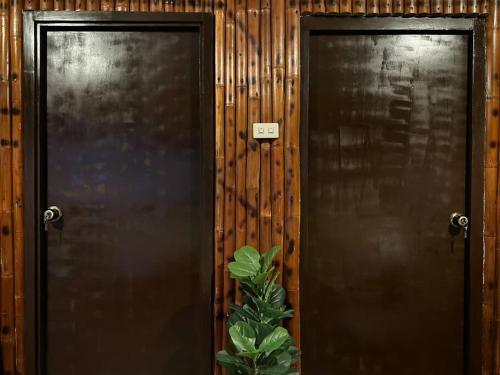 two brown doors with a plant in front of them at Amakan Beachfront Private House Bataan in Bagac