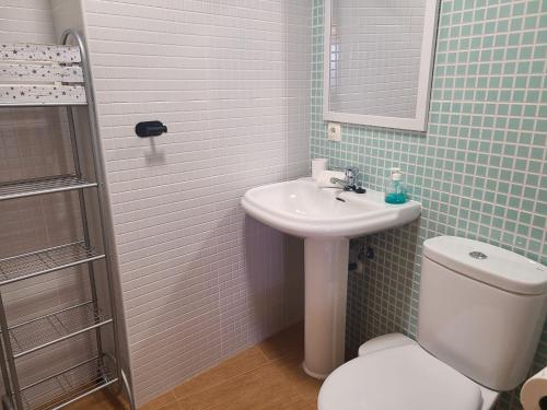 a bathroom with a sink and a toilet and a mirror at Vista Segaria Apartment in El Vergel in El Verger