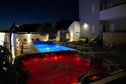 a swimming pool with a red bathtub at night at Villa Olea in Šimuni
