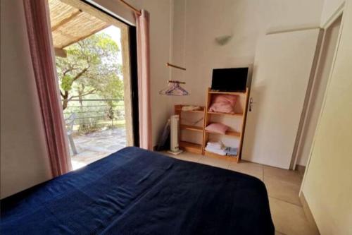 une chambre avec un lit et une grande fenêtre dans l'établissement Petit nid douillet à deux pas de Santa Giulia, à Porto-Vecchio