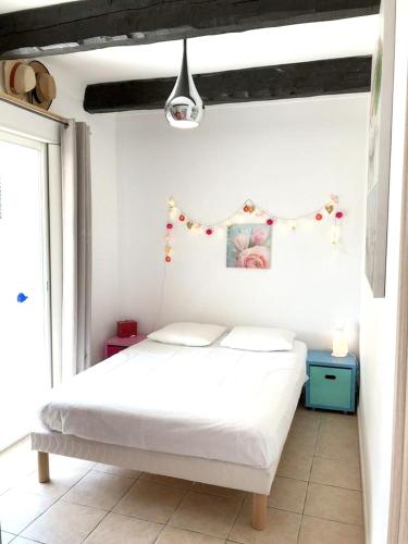 une chambre avec un lit blanc et une fenêtre dans l'établissement Appartement moderne à Antibes avec jardin et terrasse, à Antibes