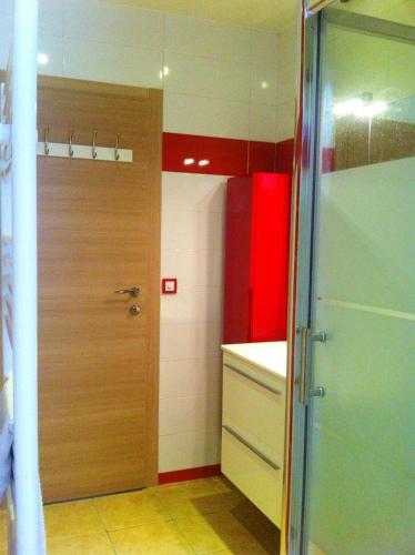 La salle de bains est pourvue d'une porte en bois et d'un lavabo. dans l'établissement Appartement moderne à Antibes avec jardin et terrasse, à Antibes