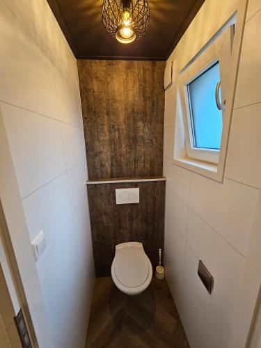 uma pequena casa de banho com um WC e uma janela em Vakantiepark de Thijmse Berg em Rhenen