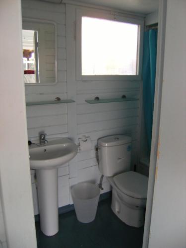 a bathroom with a toilet and a sink and a window at Bungalows Club Aire Libre in Tossa de Mar