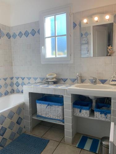une salle de bain avec un lavabo, une baignoire et un miroir dans l'établissement Maison spacieuse avec piscine partagée à Gassin, à Gassin