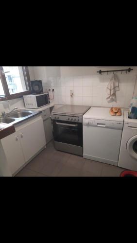 a small kitchen with a stove and a sink at Chez Bibi in Neuilly-sur-Marne