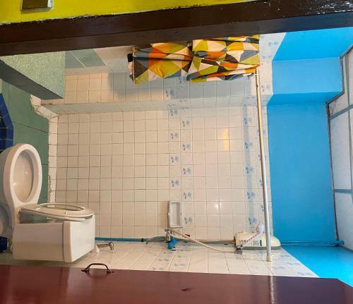 ein Badezimmer mit Toilette und gefliester Wand in der Unterkunft Riviera Beach in Pattaya