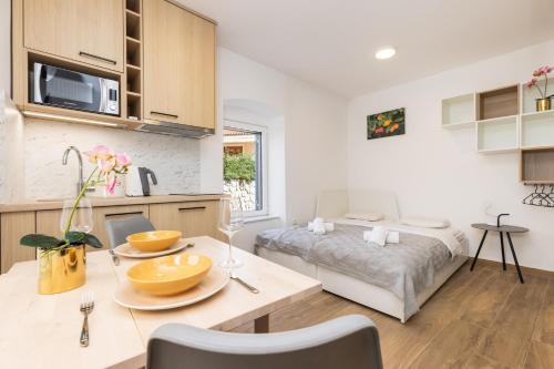 a kitchen and living room with a table and a bed at Apartments Maginja in Veli Lošinj