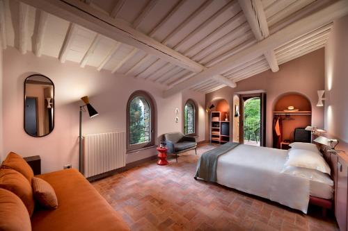 パンツァーノにあるLa Pensione di Vignamaggioのベッドルーム(大型ベッド1台、ソファ付)