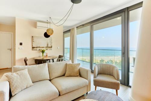 a living room with a couch and a view of the ocean at Wave - Sea View Resort&SPA 648A in Międzyzdroje