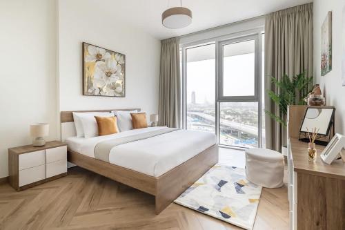 a bedroom with a large bed and a large window at Frank Porter - 1 Residences West in Dubai