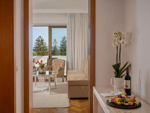 a living room with a table with a plate of fruit at Grecotel Creta Palace in Rethymno Town