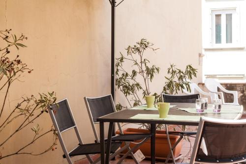 a table and chairs in a room with plants at Palazzo dei Ciompi Suites in Florence