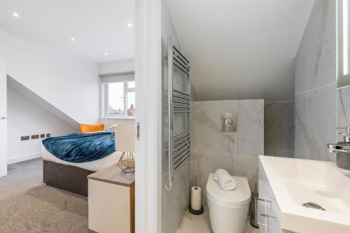 a bathroom with a toilet and a sink and a bed at Luxurious 2 BR - Apartment - Central Location in London