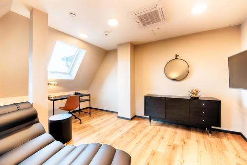 a living room with a couch and a mirror at Welcome Hotel Neckarsulm in Neckarsulm