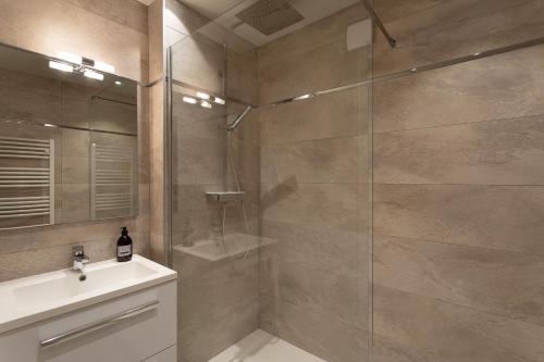 een badkamer met een douche en een wastafel bij Chez Léon - Appt à 500m des plages in Saint-Malo