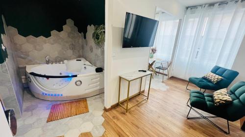 La salle de bains est pourvue d'une grande baignoire et d'une télévision. dans l'établissement Détente, Spa et Parking privé, à Lyon
