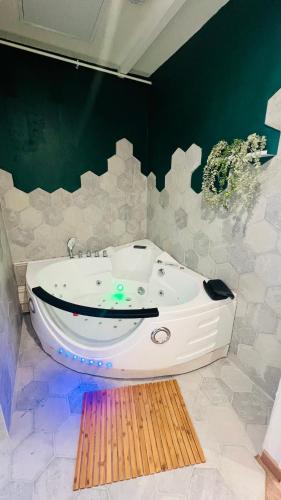 La salle de bains est pourvue d'une grande baignoire murale. dans l'établissement Détente, Spa et Parking privé, à Lyon