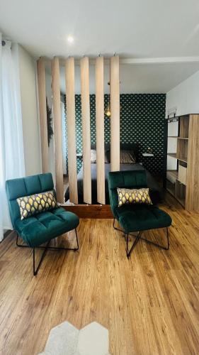 - un salon avec deux chaises vertes et un lit dans l'établissement Détente, Spa et Parking privé, à Lyon