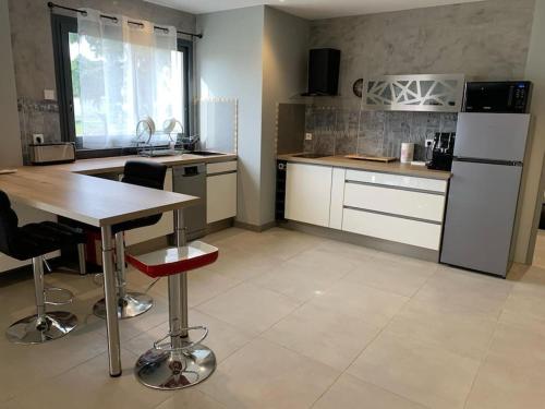 a kitchen with a table and a refrigerator at Cocon Grand Large in Décines-Charpieu