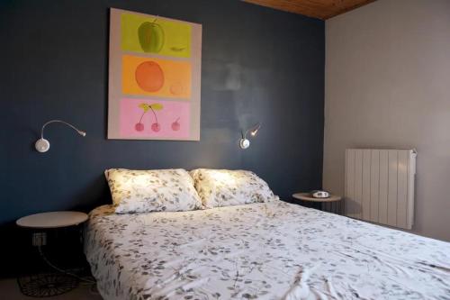 a bedroom with a bed and a painting on the wall at Maison grande terrasse 5min plage in La Barre-de-Monts