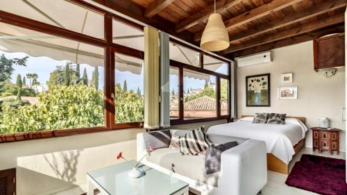 a bedroom with a bed and a large window at Suite con vistas Alhambra in Granada