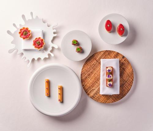four white plates with different types of desserts at Relais Bernard Loiseau in Saulieu