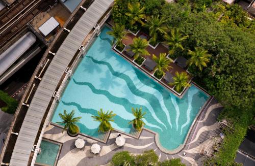 an overhead view of a swimming pool with palm trees at Emporium Suites by Chatrium in Bangkok