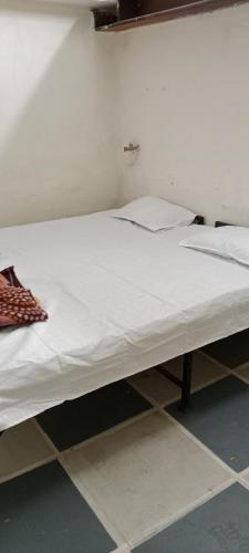 uma grande cama branca num quarto em Shree Shivaya Guest House em Ujaim