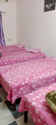 duas camas com lençóis cor-de-rosa num quarto em Shree Shivaya Guest House em Ujaim