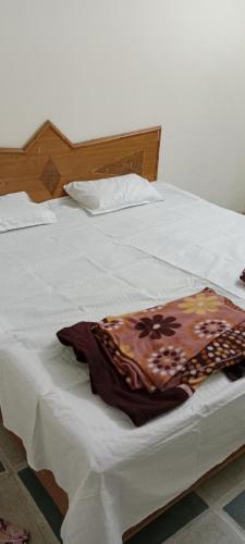 uma cama branca com um cobertor em cima em Shree Shivaya Guest House em Ujaim