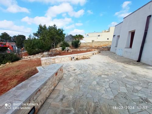 a stone patio with a retaining wall next to a building at VILLA IL PIGNO ZONA MALDIVE DEL SALENTO in Marina di Pescoluse