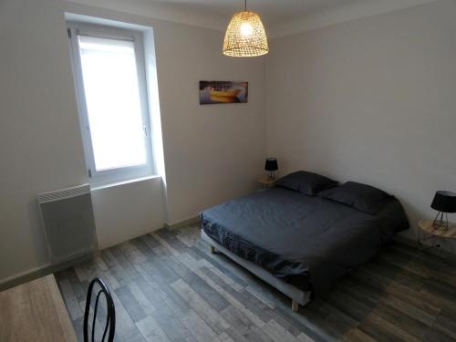 une chambre avec un lit et une grande fenêtre dans l'établissement Maison de village, à Baix