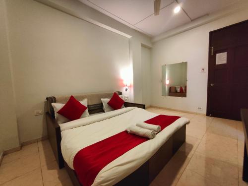 a bedroom with a large bed with red pillows at Rain Raga Resort in Mahabaleshwar