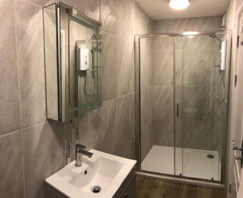 een badkamer met een glazen douche en een wastafel bij Beacon Hotel Self Catering Apartment in St. Agnes 