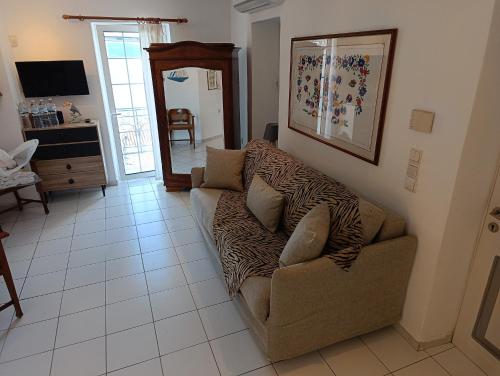 a living room with a couch on a tiled floor at Summer Dream in Poros