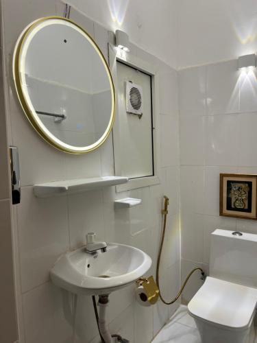 ein Badezimmer mit einem Waschbecken, einem Spiegel und einem WC in der Unterkunft كورنيش عجمان in Ajman 