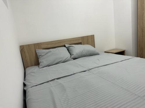 ヴェリコ・グラディシュテにあるApartman Auroraのベッド1台(木製ヘッドボード、枕2つ付)