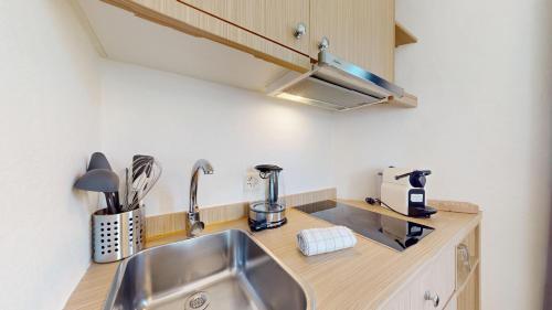 Charming apartments in the center of Lutry في لوتري: مطبخ مع حوض حديد قابل للصدأ وموقد