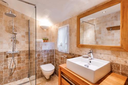 a bathroom with a sink and a toilet and a mirror at Maison pour 10, accès direct à la plage in Ars-en-Ré