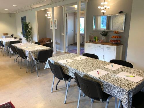 a room with several tables and chairs and a kitchen at Bogesund Slottsvandrarhem in Vaxholm