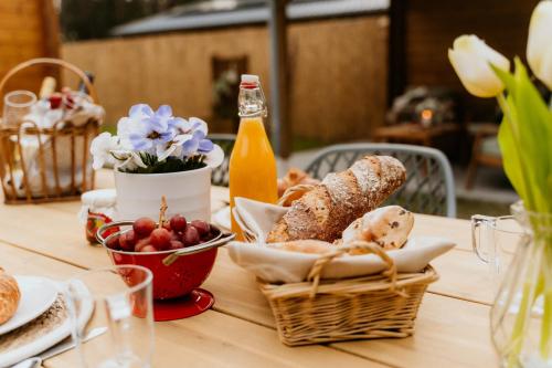 a table with a basket of bread and a bottle of beer at Romantisch Wellness Boshuisje met Sauna & Hottub in Meijel