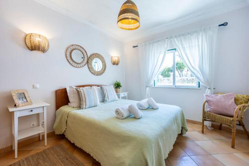 1 dormitorio con 1 cama con 2 toallas en Villa som das Ondas, en Budens