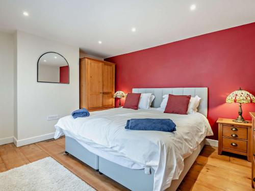 a bedroom with a large bed with a red wall at 3 Bed in Broughton 94143 in Broughton