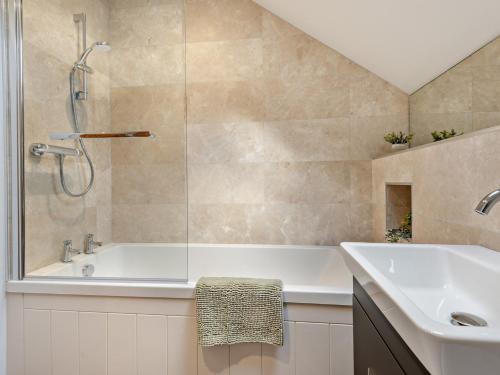 a bathroom with a shower and a tub and a sink at 3 Bed in Loweswater 94152 in Arlecdon