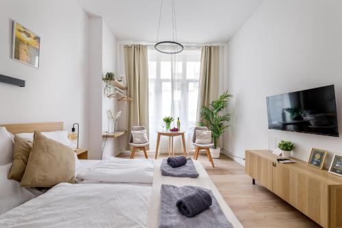 a white bedroom with a bed and a tv at AK7 Boutique Suites in Budapest