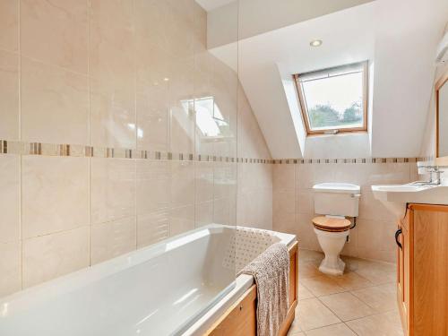 a bathroom with a tub and a toilet and a sink at 3 Bed in Lower Rochford 94240 in Newnham